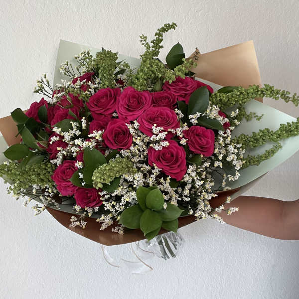 Bouquet of hot pink roses with white filler flowers and greenery