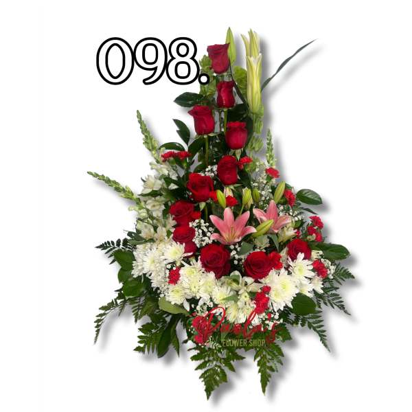 Tall floral arrangement with red roses, pink lilies, and white flowers