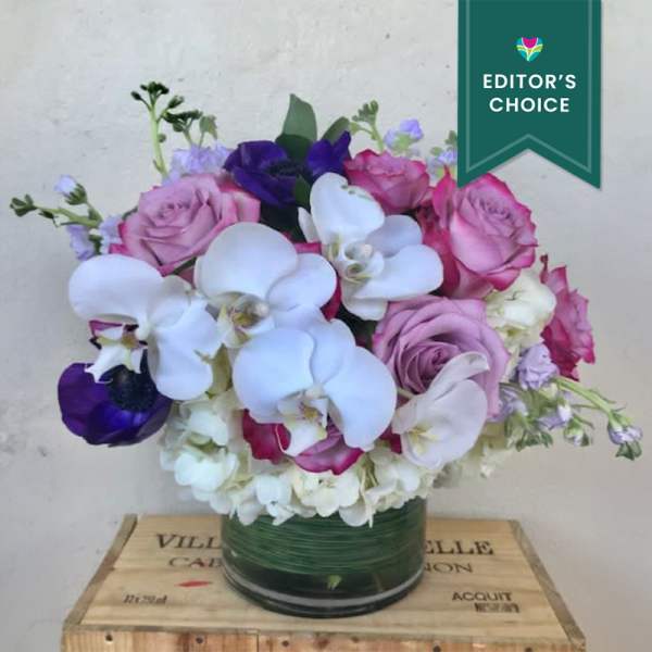 Pink roses and white orchids arranged in a glass vase