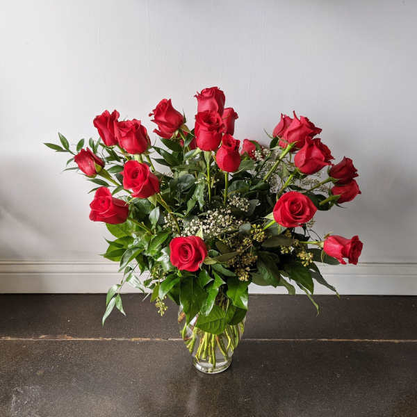 Red roses arranged in a clear glass vase