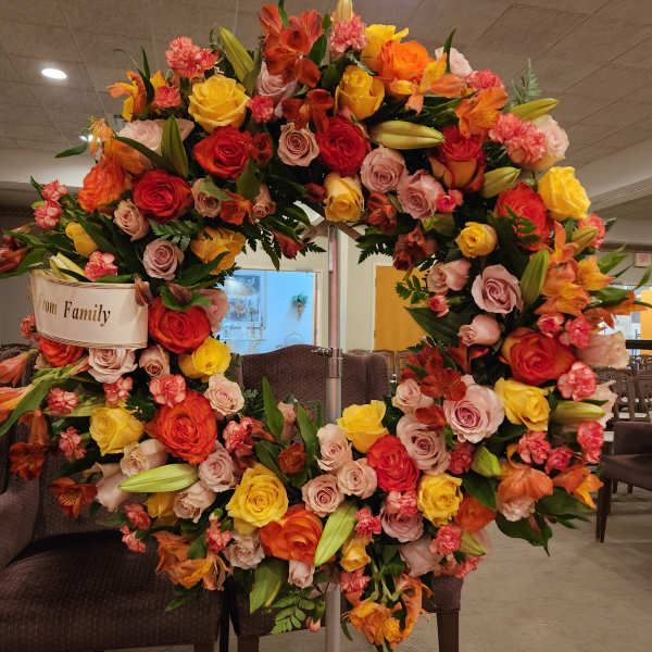 Large floral wreath with roses and lilies on a stand