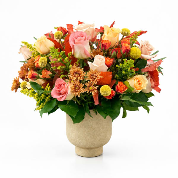 Mixed roses and mums arranged in a beige vase
