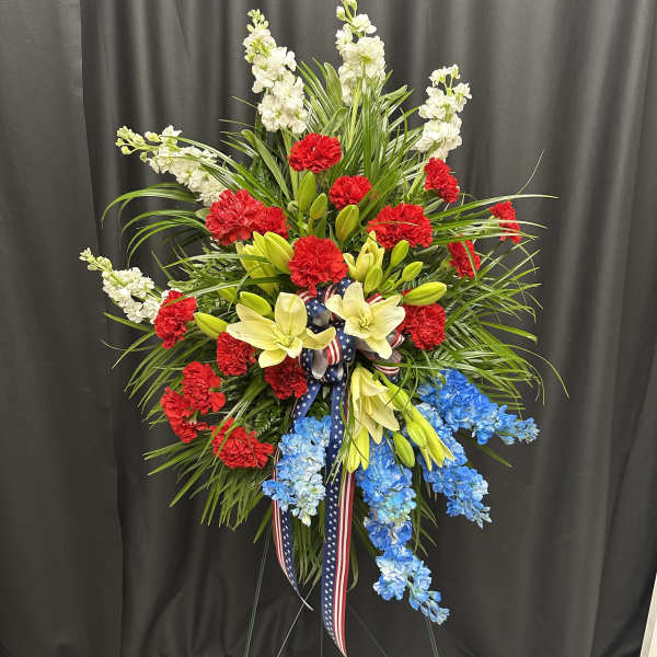Standing floral spray with red, white, yellow, and blue flowers