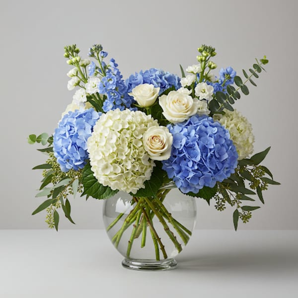 Blue and white flower arrangement in a clear glass vase