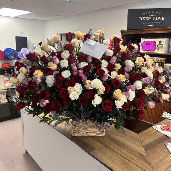 Large basket arrangement of red, white, pink, and peach roses