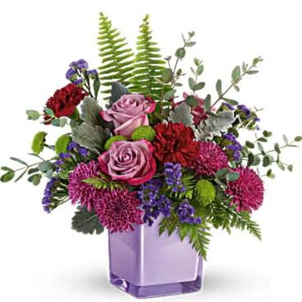 Purple and pink flower arrangement in a lavender vase