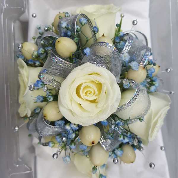 White rose bouquet with blue accents and silver ribbon in a clear box