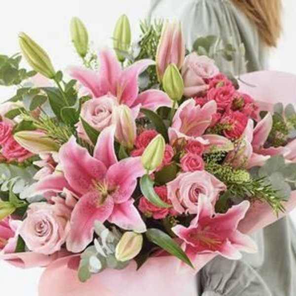 Pink lilies and roses in a hand-tied bouquet