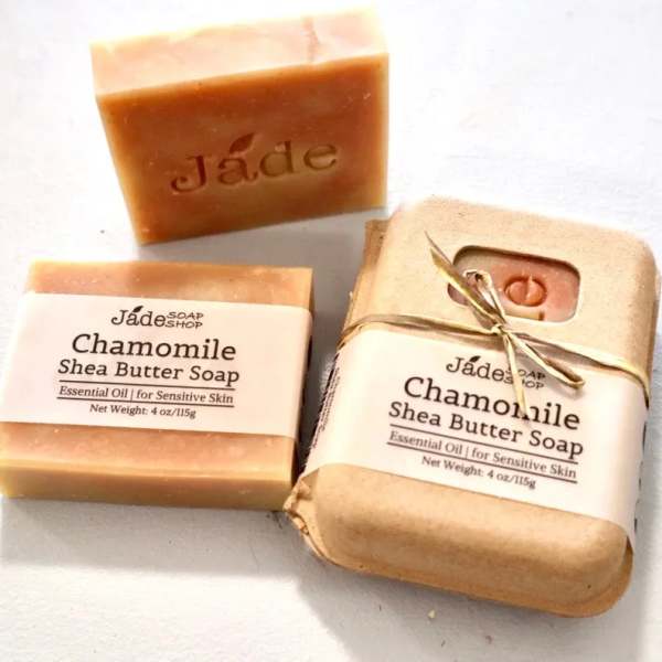 Set of three chamomile shea butter soap bars, one wrapped and two unwrapped on a light surface
