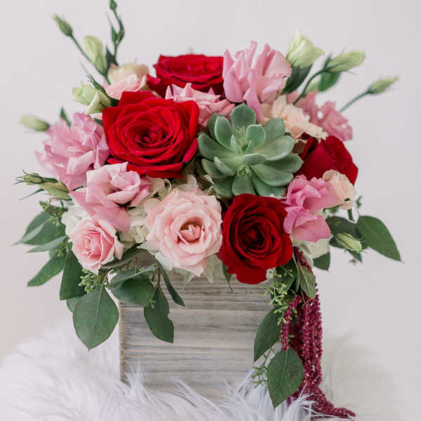 Pink and red rose bouquet with a succulent in a wooden box