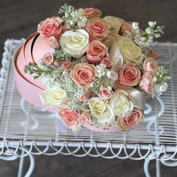 Bouquet of pink and white roses in a round pink box