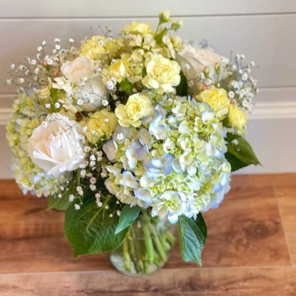 Bouquet of pale yellow and white flowers in a glass vase