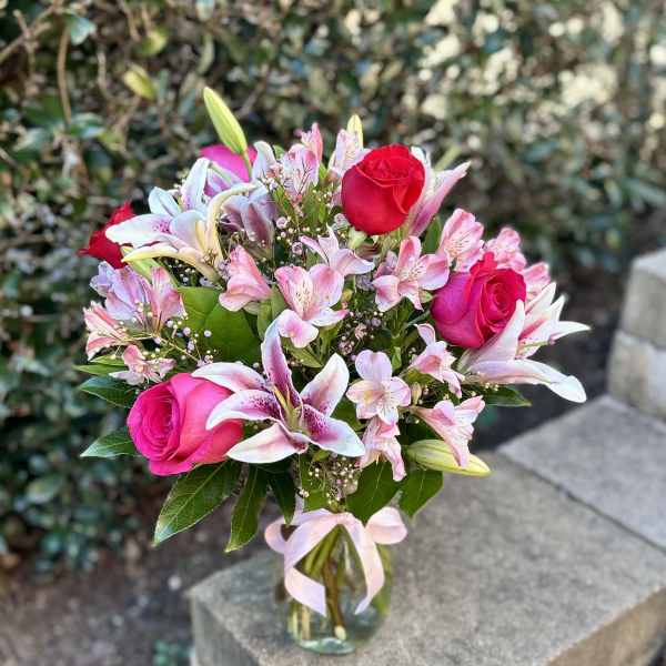 Bouquet of pink roses and lilies in a clear glass vase