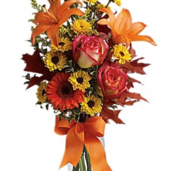 Bouquet of orange lilies, roses, and daisies with an orange ribbon