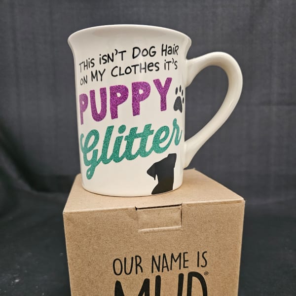 White mug with a dog-themed quote sitting on a cardboard box