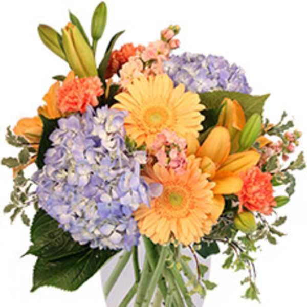 Mixed bouquet of pastel flowers in a clear glass vase