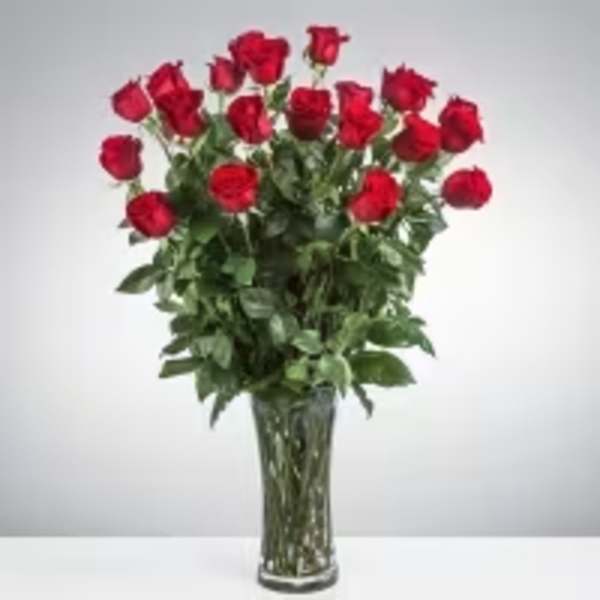 Tall arrangement of red roses in a clear glass vase