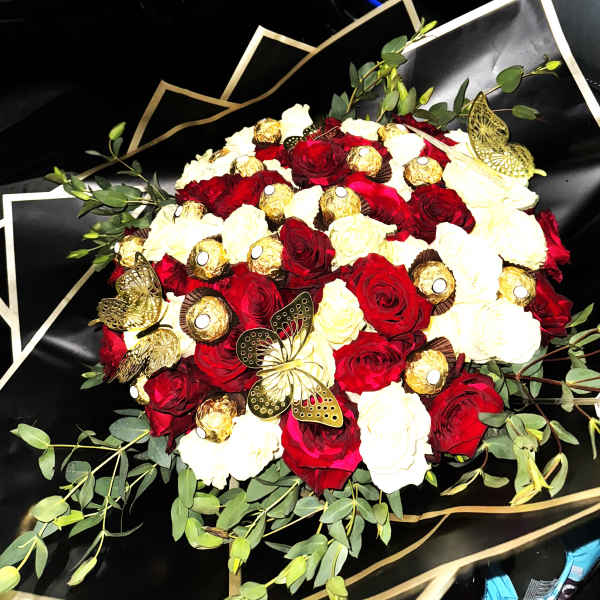 Round bouquet of red and white roses with gold-wrapped chocolates and gold butterflies in black wrapping