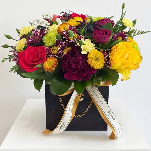 Mixed bouquet of roses and chrysanthemums in a black gift box with ribbon