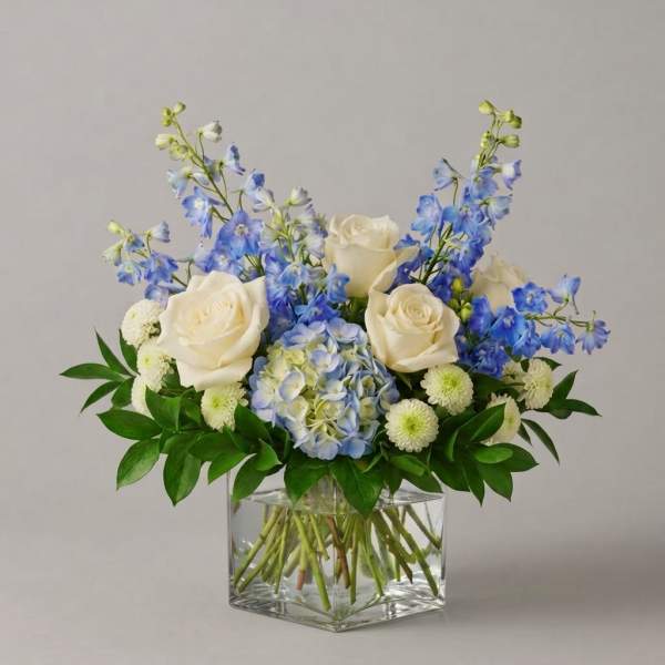 Blue and white floral arrangement in a clear square vase