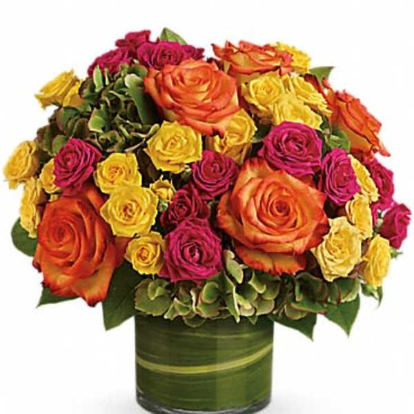 Bouquet of orange, yellow, and pink roses in a green vase