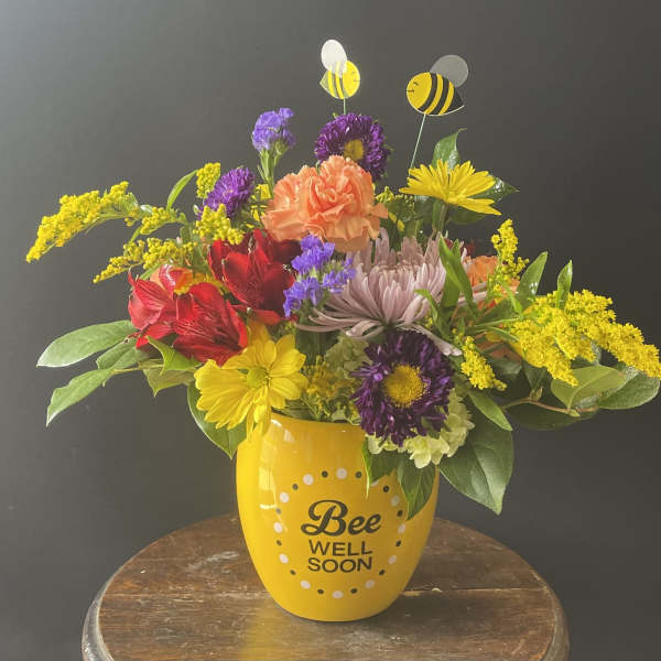 Colorful bouquet in a yellow "Bee Well Soon" mug with bee picks