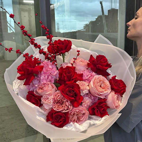 Large bouquet of red and pink roses with berry branches