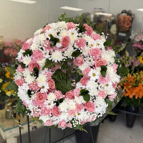 Pink and white floral wreath on a stand