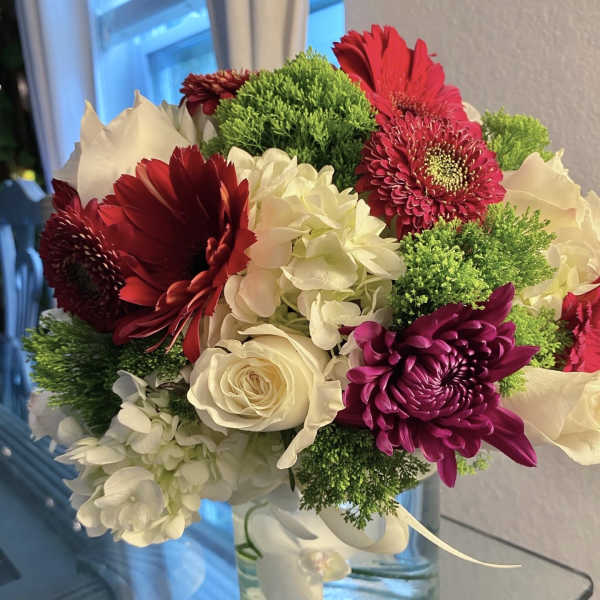 Bouquet of red and white flowers in a clear glass vase