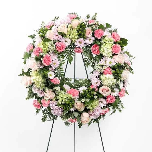 Floral wreath on a black easel with pink and white flowers