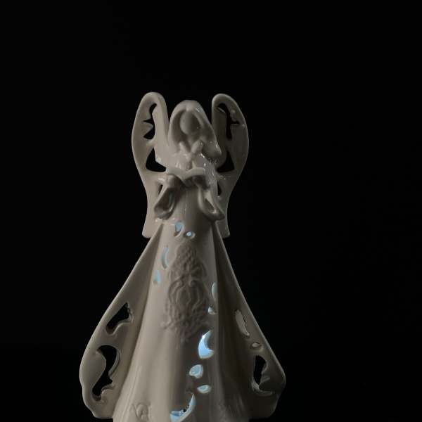 White ceramic angel figurine with cutout details