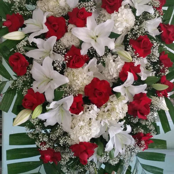 Large standing spray of red roses, white lilies, and white hydrangeas