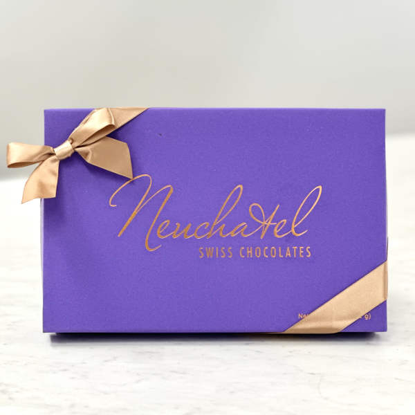 Purple box of Neuchatel Swiss chocolates tied with gold ribbon