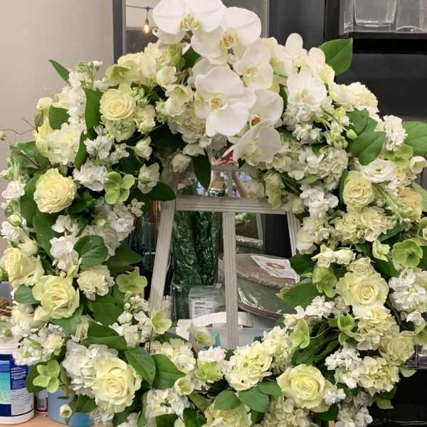Large white floral wreath with roses and orchids