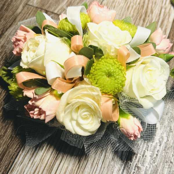 Bouquet of white roses, pink carnations, and green pom-poms with ribbon