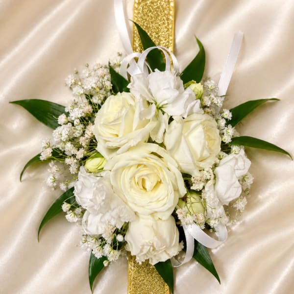White rose bouquet with baby's breath and ribbon on satin fabric