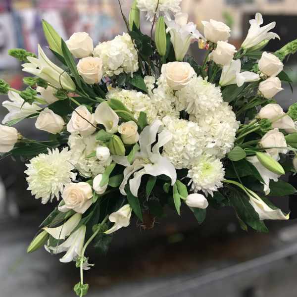 White floral arrangement with roses, lilies, and hydrangeas