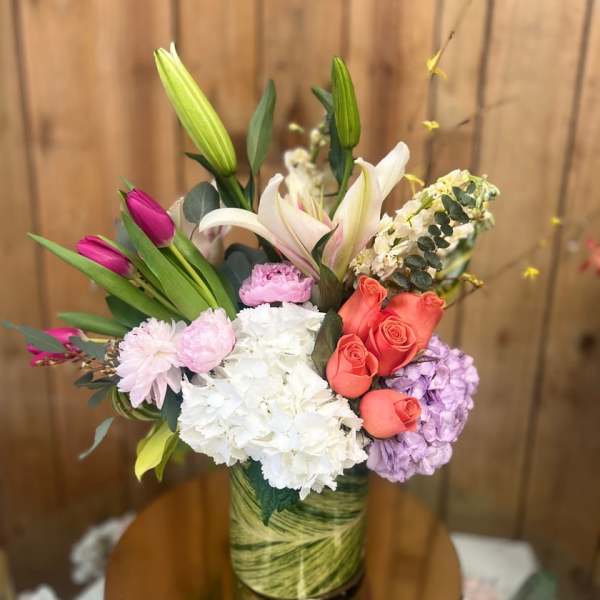 Mixed bouquet with lilies, roses, hydrangeas, and carnations in a vase
