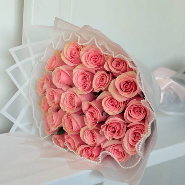 Bouquet of pink roses wrapped in sheer pink paper