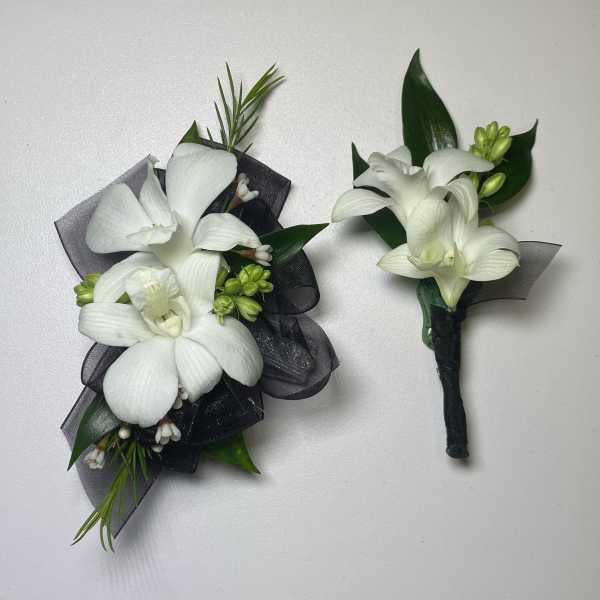 White orchid corsage and boutonniere with black ribbon accents