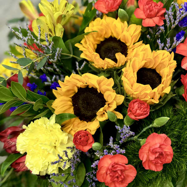 Bright bouquet with sunflowers, red carnations, and yellow blooms