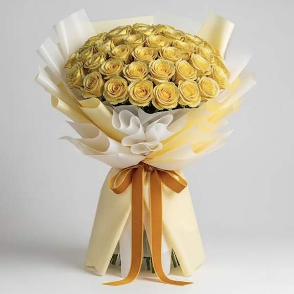 Bouquet of yellow roses wrapped in cream paper with an orange ribbon