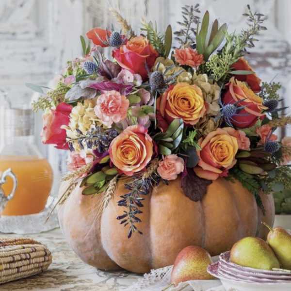 Floral arrangement in a pumpkin centerpiece with pears nearby