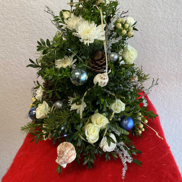 Christmas tree-shaped floral arrangement with white flowers and ornaments