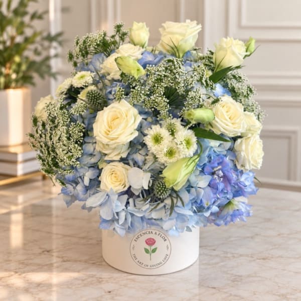 Blue and white floral arrangement in a round white box