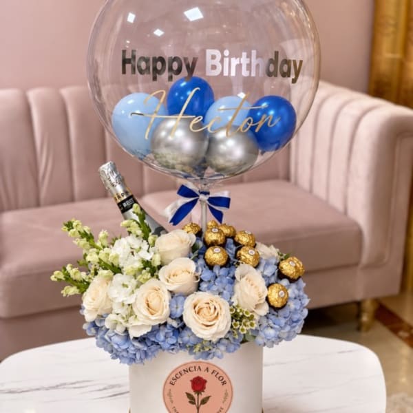 Birthday balloon over a flower box with roses, hydrangeas, and chocolates