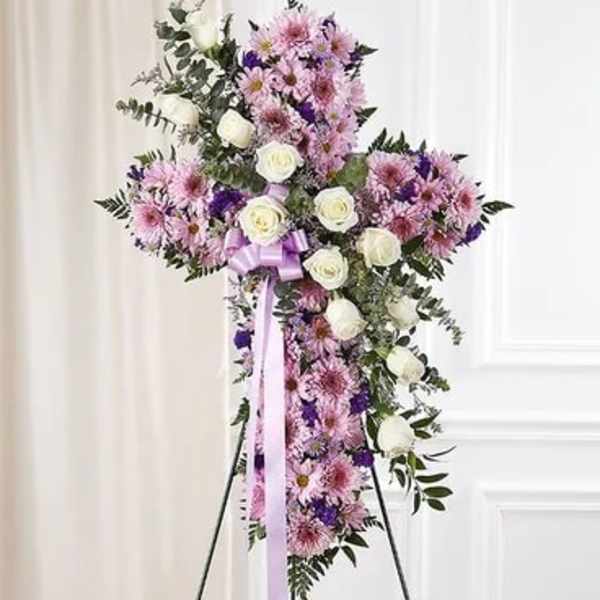Standing floral cross with pink and white flowers on an easel