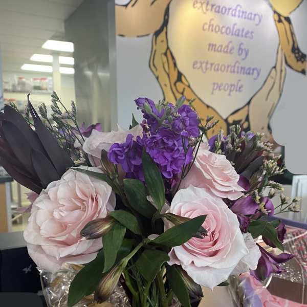 Pink and purple bouquet in a glass jar tied with a pink ribbon