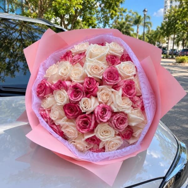 Bouquet of pink and cream roses wrapped in pink paper