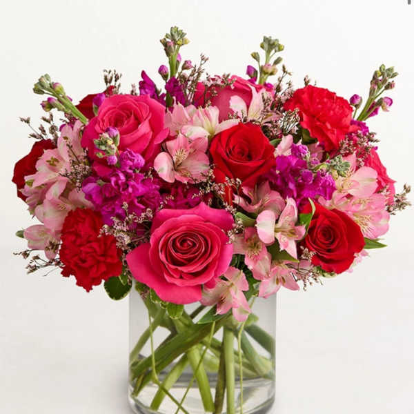Bouquet of pink and red roses with pale pink alstroemeria in a clear glass vase